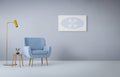 Modern interior with a blue armchair, yellow floor lamp and abstract blue and white artwork on a light blue wall.